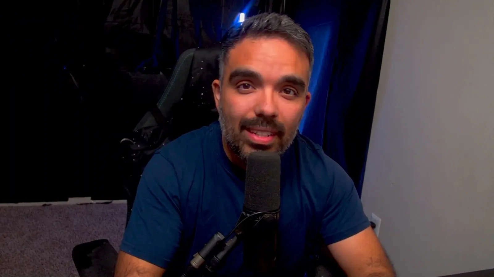 AniimoSync on camera at his microphone during the Aniimo gacha video, in the section asking why Pawprint does not simply sell the cosmetics at a fixed price