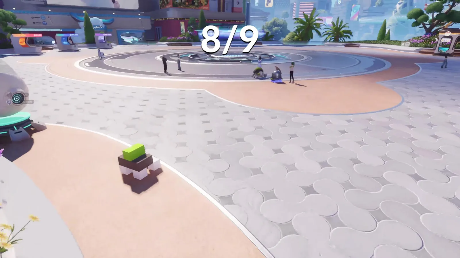 Aniimo brown cubic Voxel figure with a green top on the pavement of Horizon Square in Astra, the square’s central plaza behind it