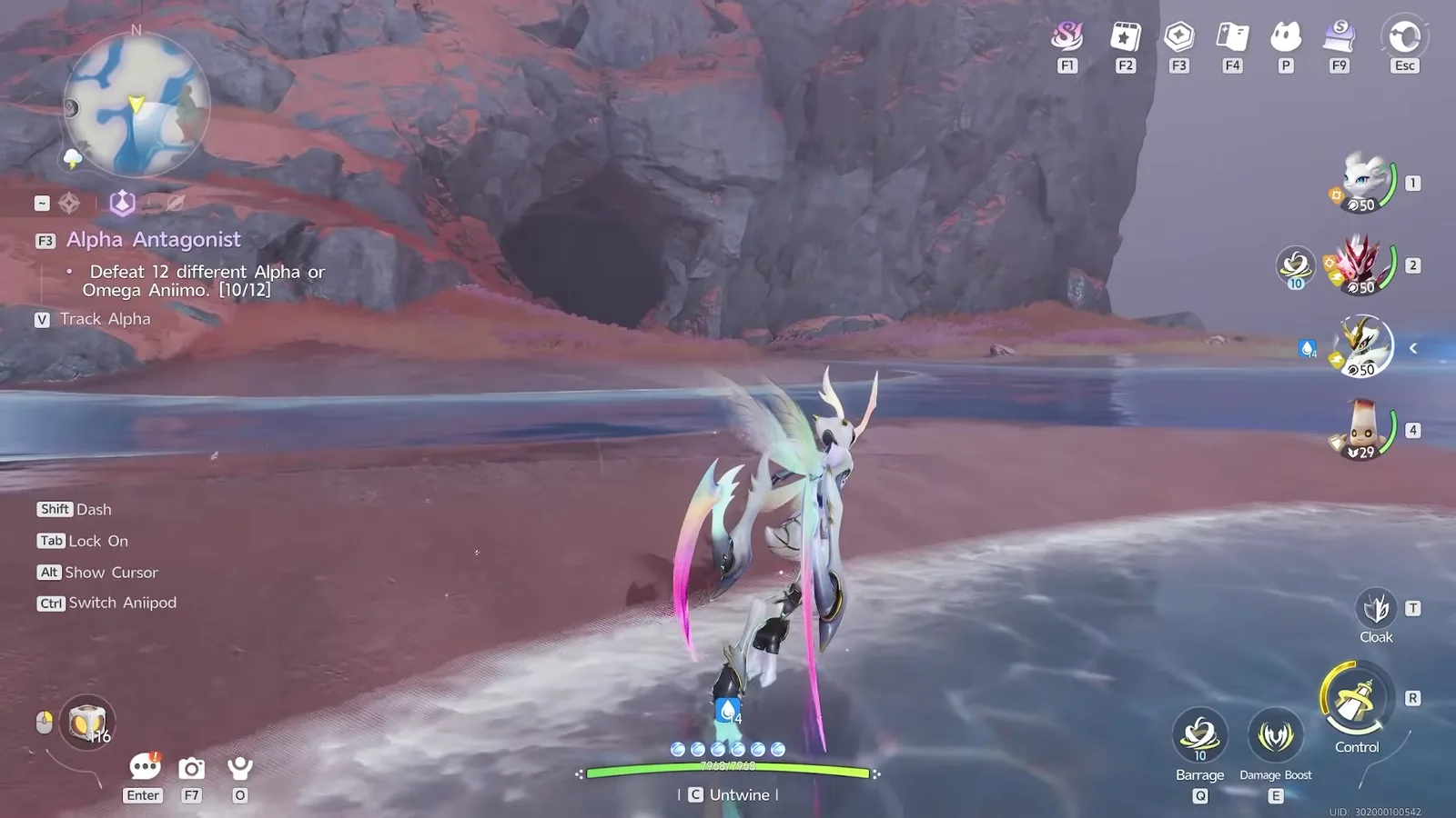 The cave mouth on Tideblossom Coast in Aniimo, a dark arch at the foot of a red cliff with a shallow channel of water running into it and the Alpha Antagonist quest tracker on the left